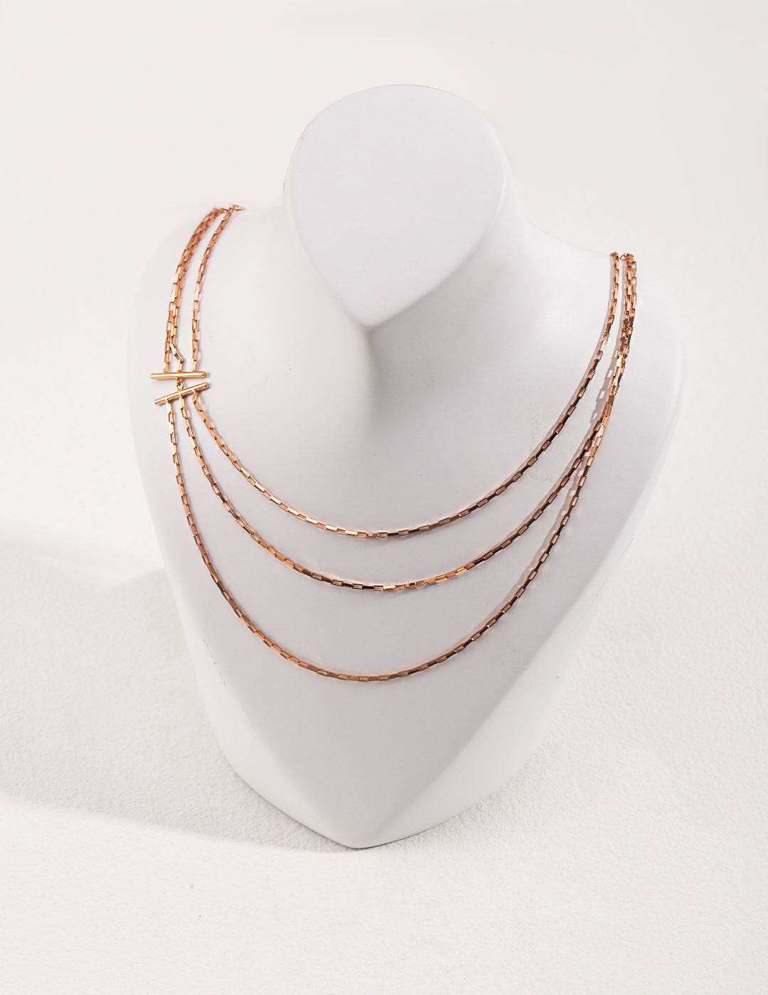 A triple-strand gold chain necklace with layers of delicate gold chains.