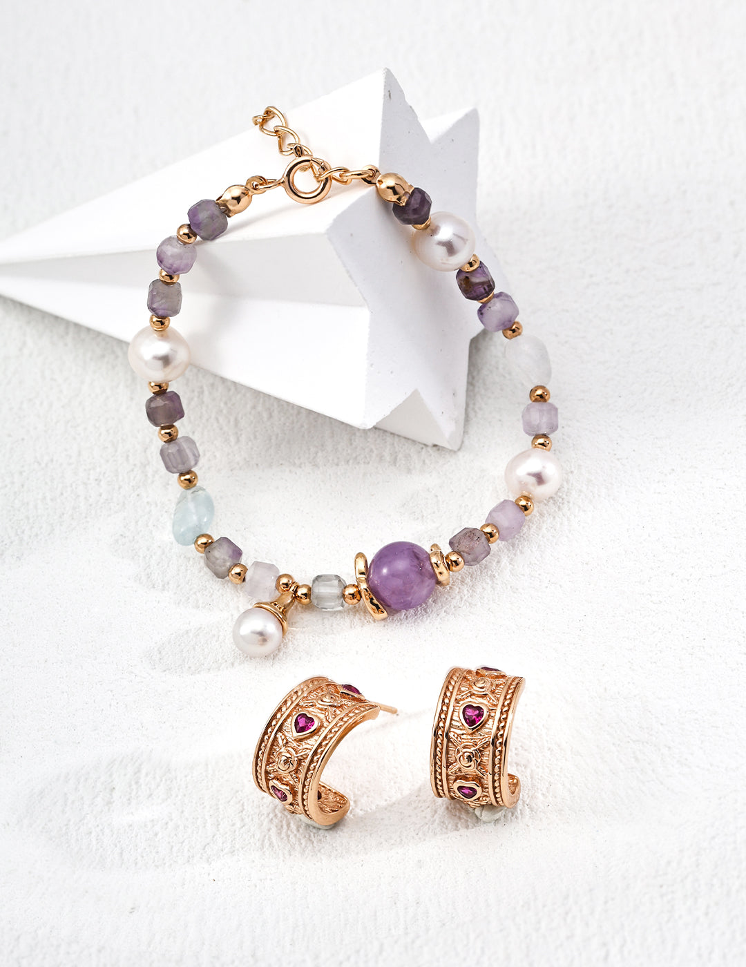 Jewelry set with a bracelet and earrings, showcasing purple amethyst and icy aquamarine stones.