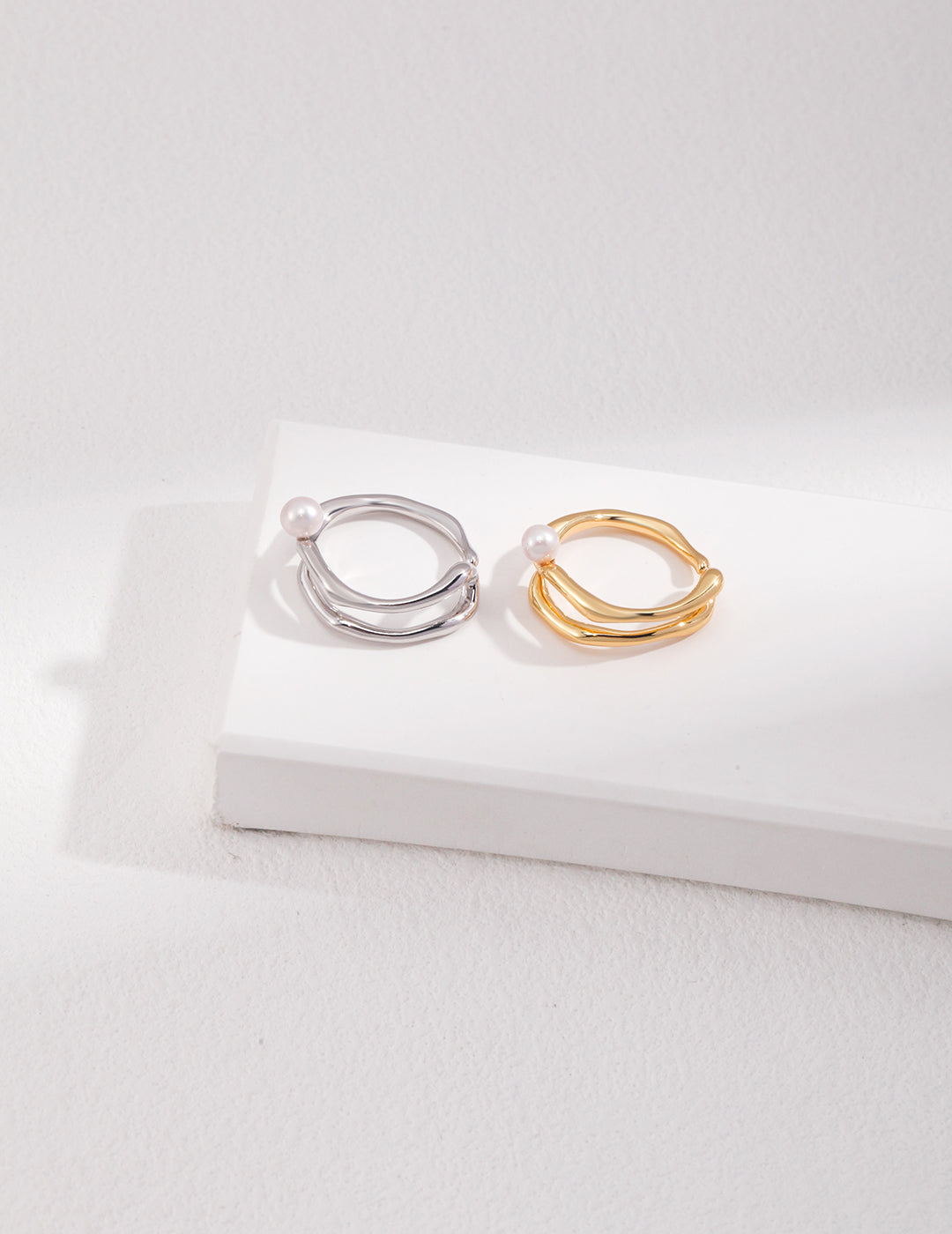 Two rings: one gold-plated, one silver-plated, featuring a unique design with freshwater pearl.