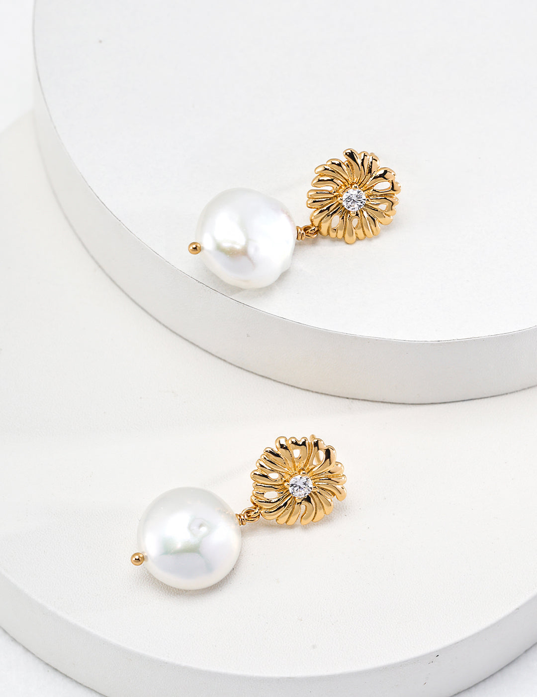 Elegant gold plated pearl earrings with daisy design.