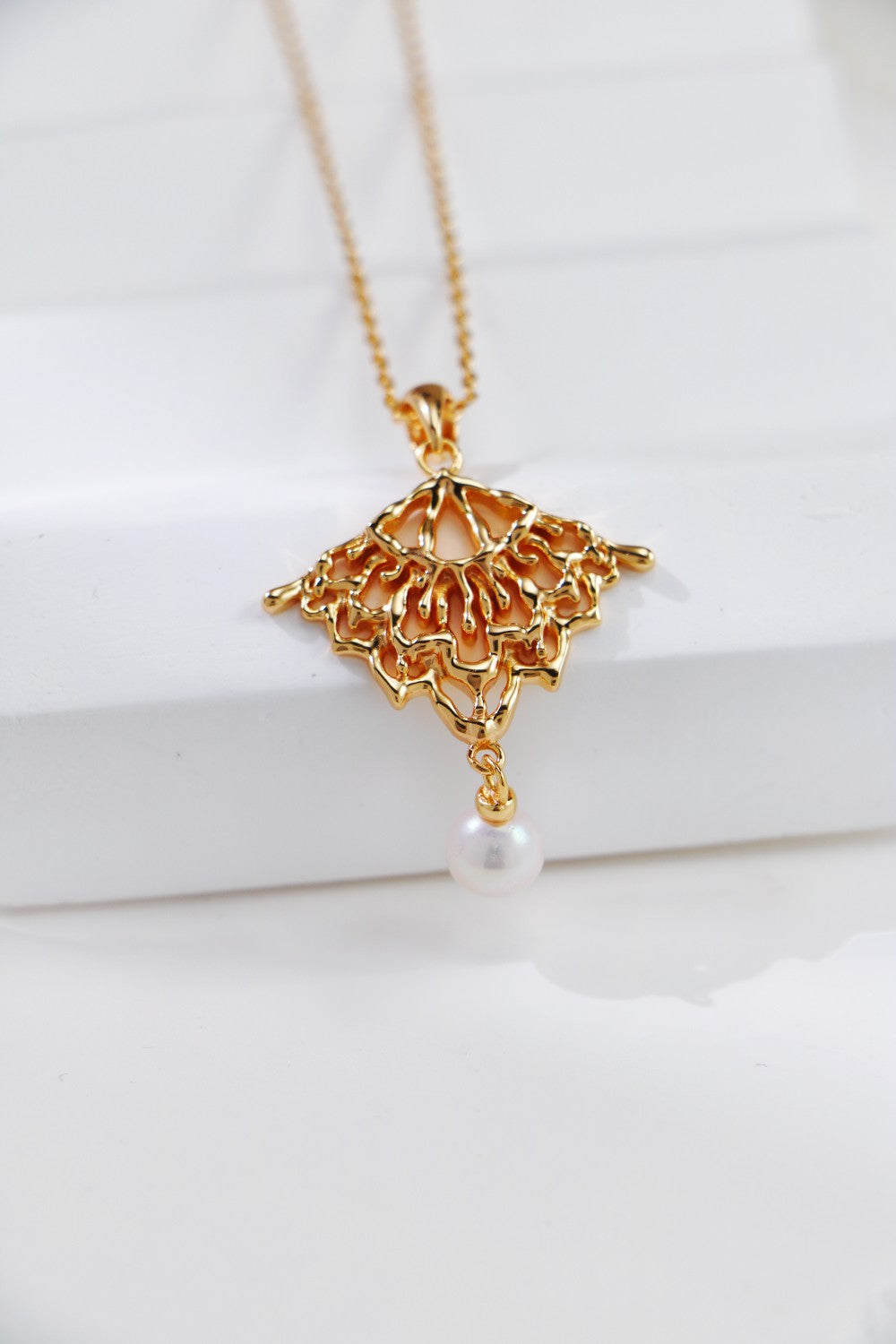 Stunning gold-plated necklace adorned with a pearl and charming lacework, ideal for adding a touch of elegance.