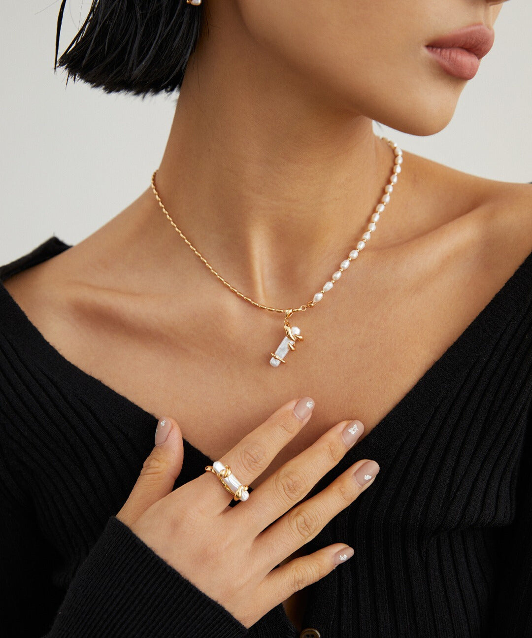 A model wearing a baroque pearls necklace, complemented by a pearl ring.