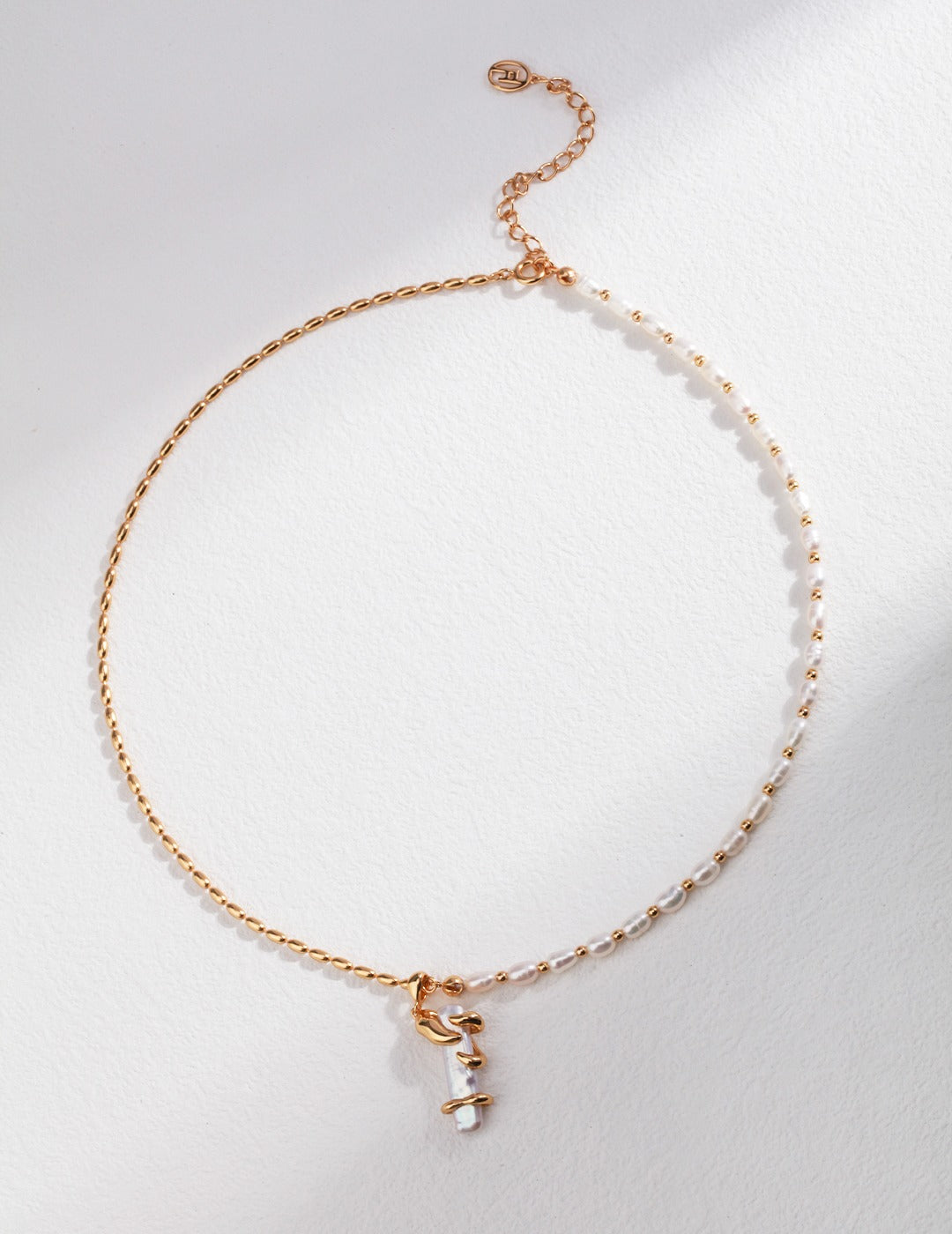 Gold chain necklace with a delicate baroque pearl pendant.