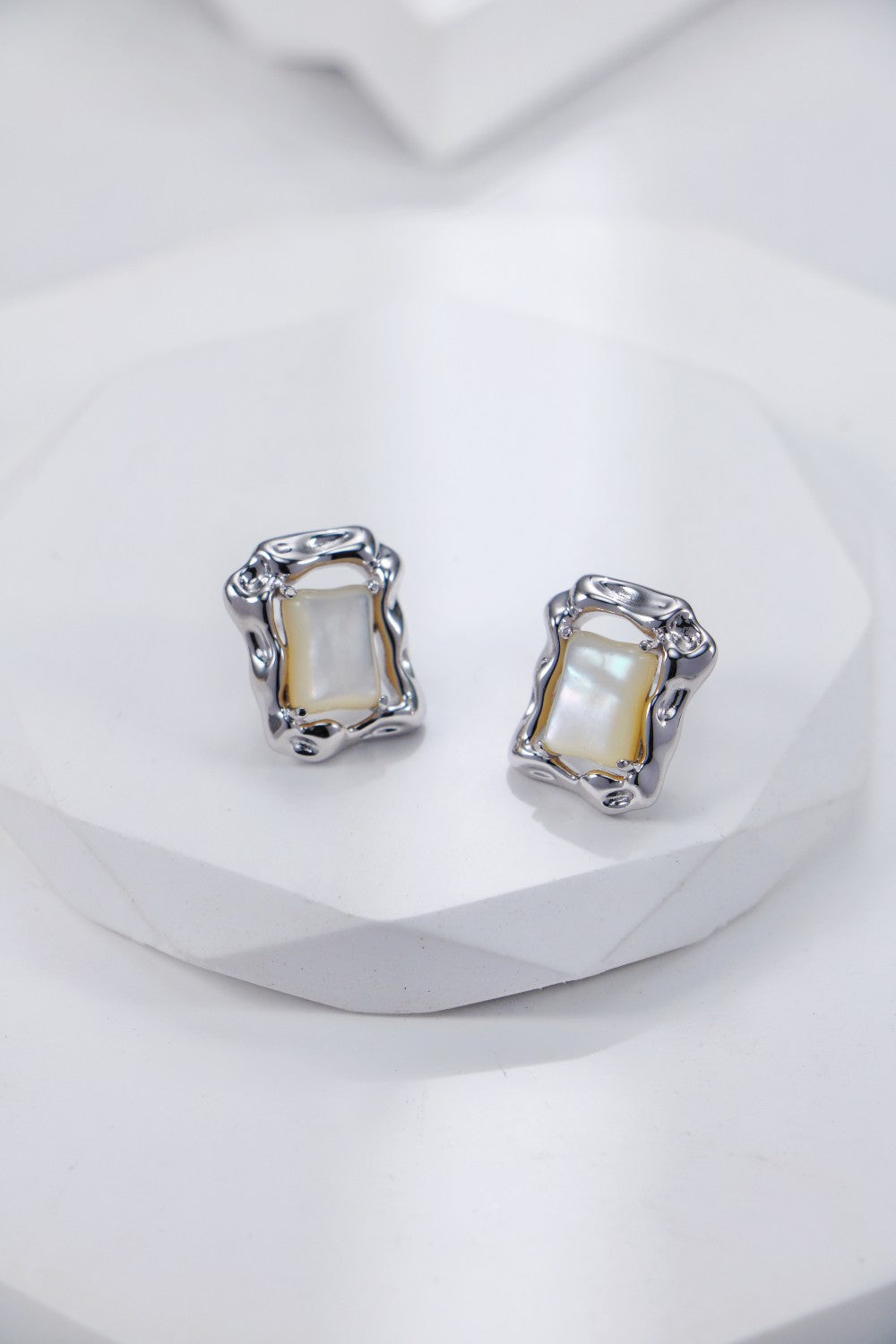 Elegant square earrings made of mother of pearl, reflecting light and adding a touch of class to any outfit.