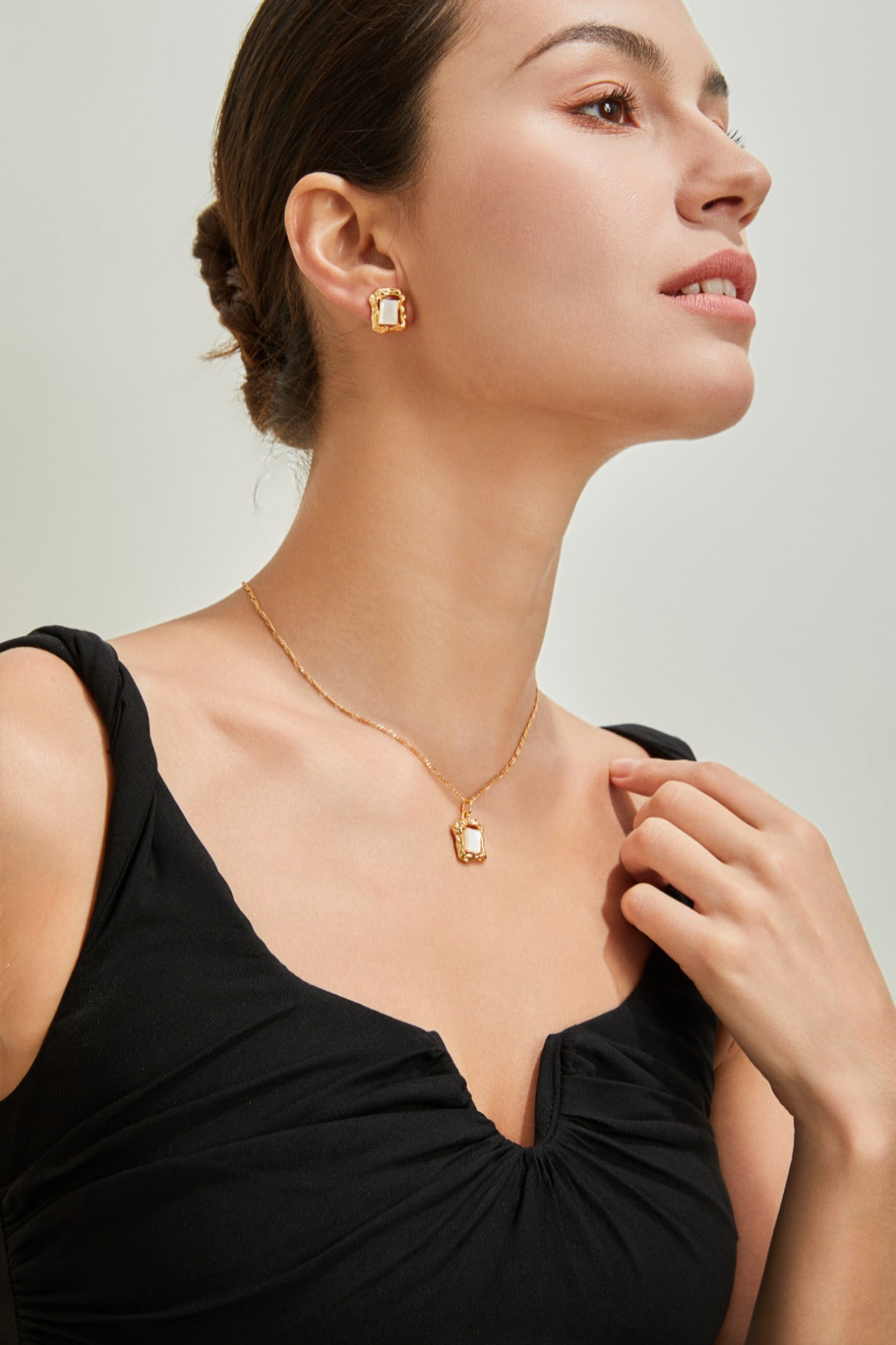 Elegant woman adorned with a beautiful gold necklace and earrings, highlighting her sophisticated fashion sense.