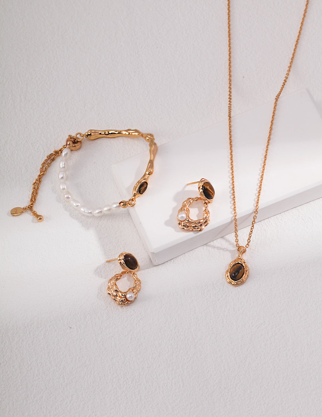 Gold plated necklace, earrings, and bracelet set with a charming tiger's eye pendant and matching jewelry.