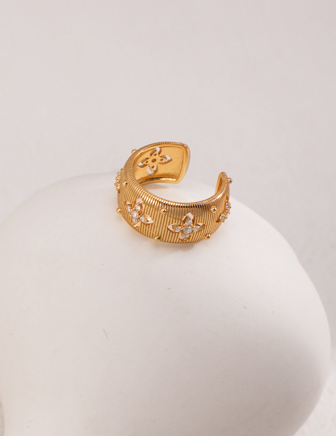 Luxurious gold ring featuring sparkling cubic zirconia on white orb.