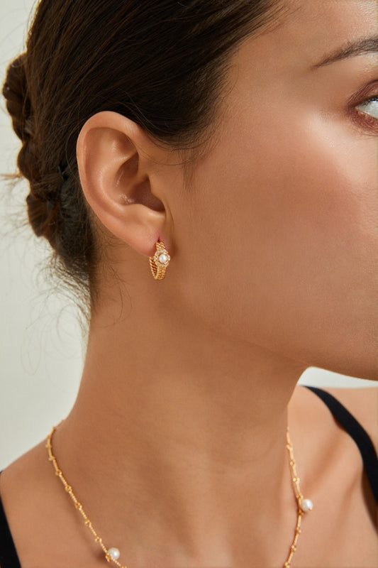 Close-up of pearl hoop earrings with intricate chain and braided band designs | Mezuille