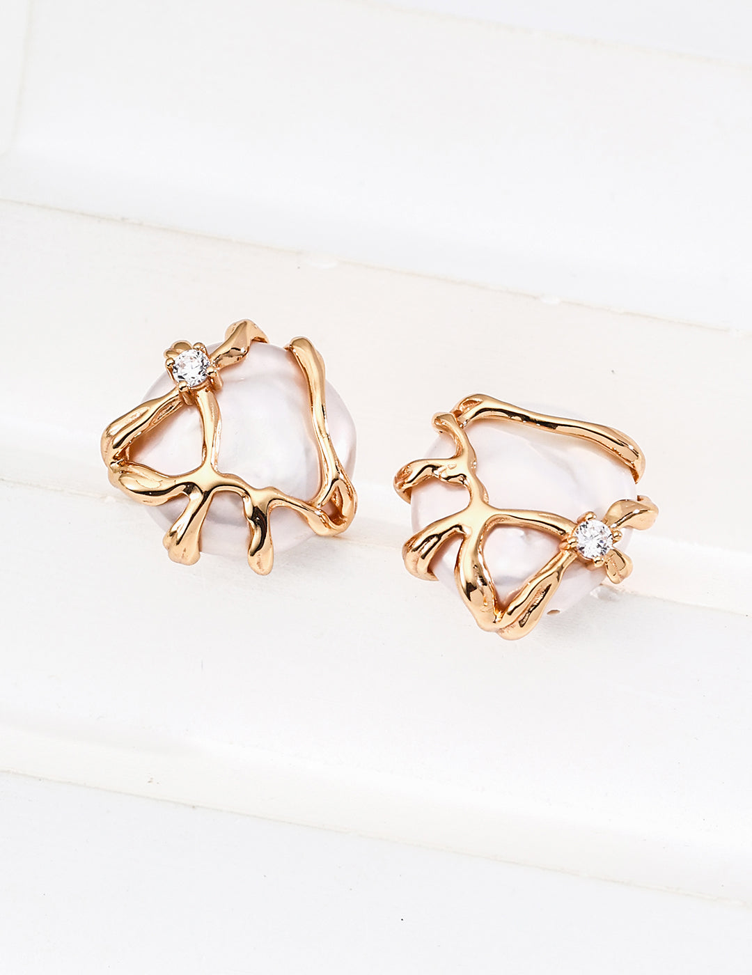 Close-up of Alexi freshwater pearl stud earrings in 18k gold vermeil with cubic zirconia accents on a clean white background.