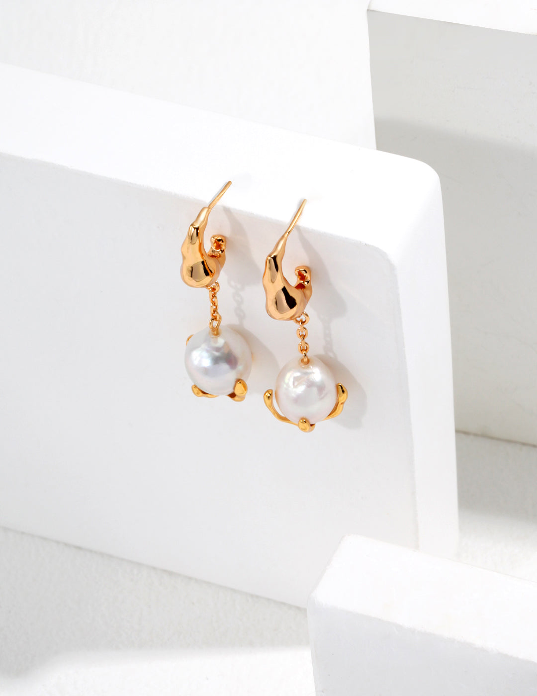 Stunning gold-plated earrings with gracefully suspended pearls, ideal for enhancing your jewelry collection.