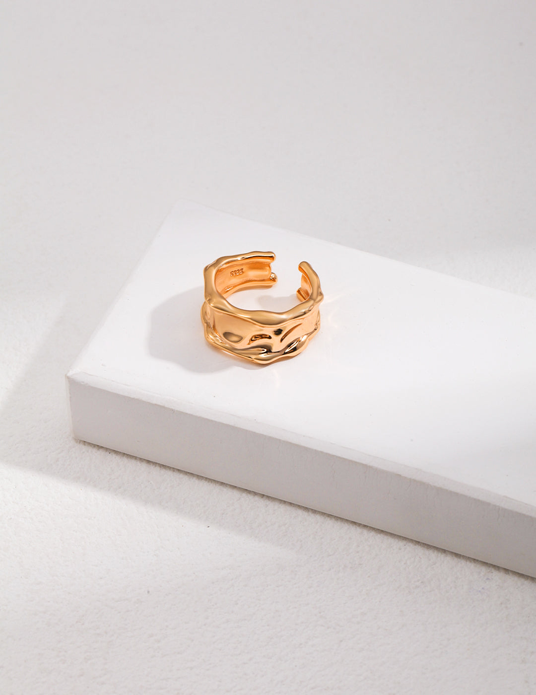 Stylish gold ring placed on top of white box