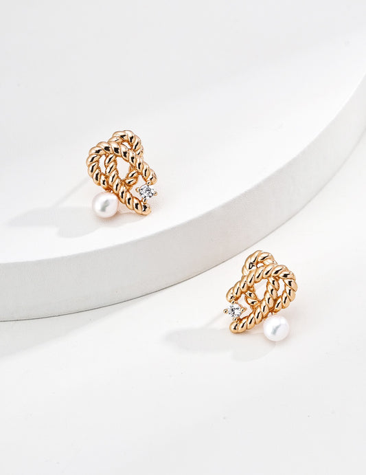 A pair of gold Mezuille studs with zirconia and pearls, sleek style.