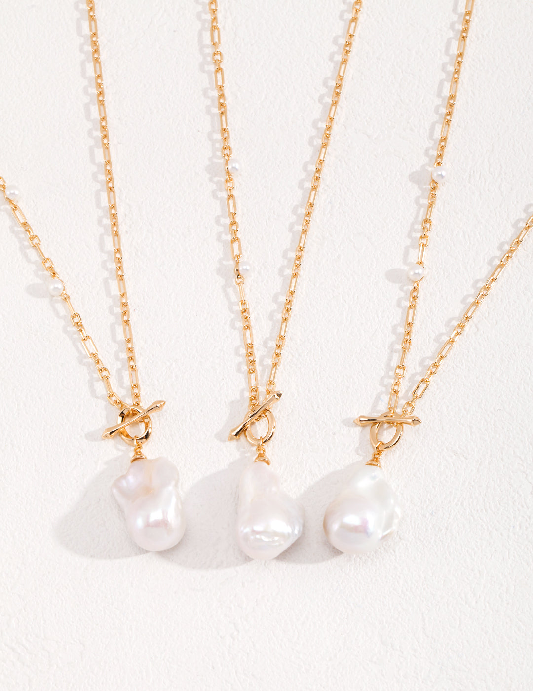 Three white pearls on gold chains, shimmering with elegance and grace. A timeless accessory that exudes sophistication.