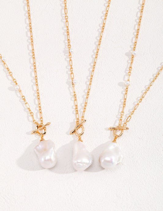 Three white pearls on gold chains, shimmering with elegance and grace. A timeless accessory that exudes sophistication.