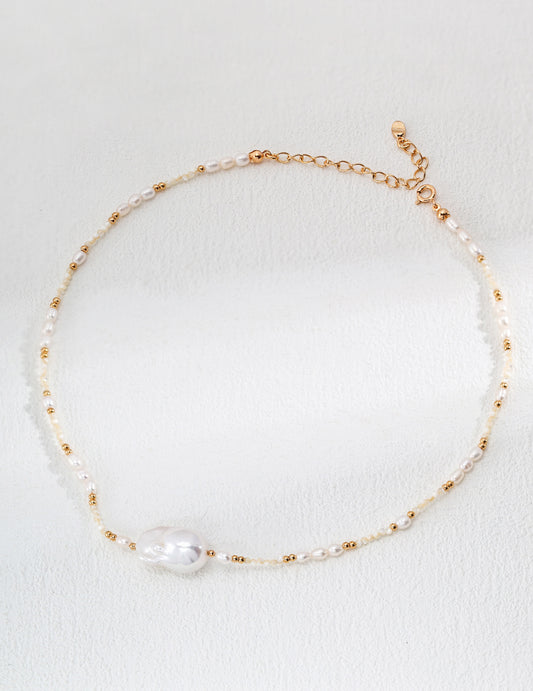 Beautiful gold and white pearl necklace resting on a delicate surface, emphasizing its elegance and sophisticated style.