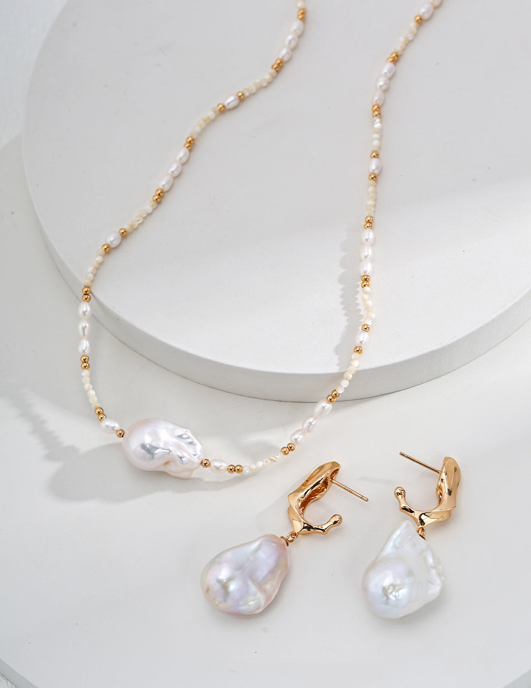 Chic pearl necklace and matching earrings displayed elegantly on smooth white surface.