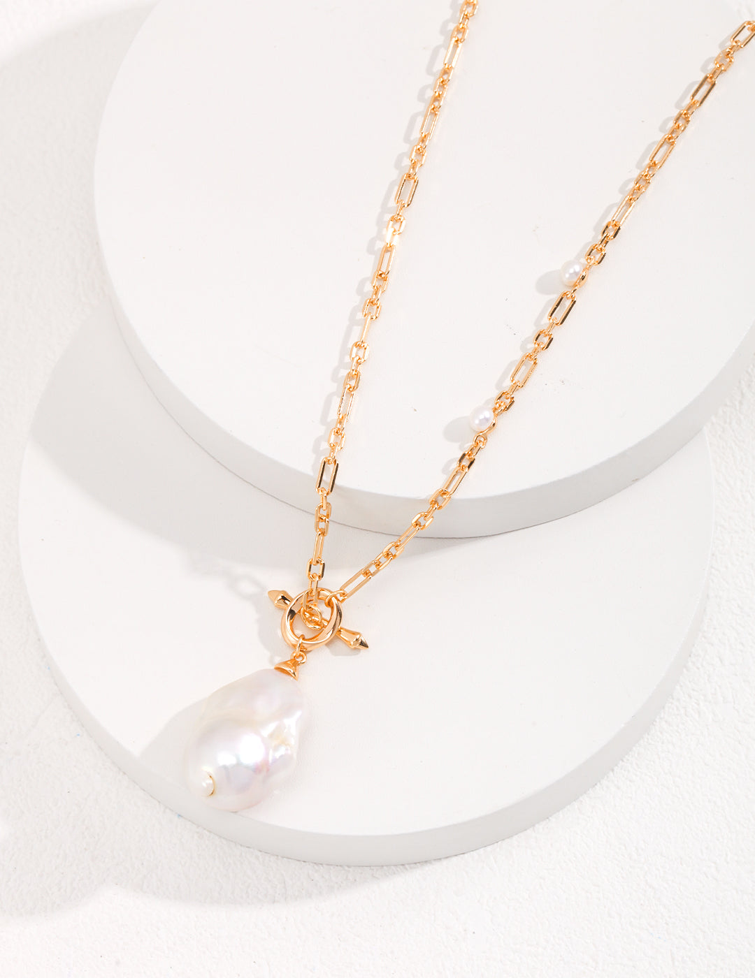 Classic gold necklace adorned with a beautiful pearl pendant, a must-have accessory.