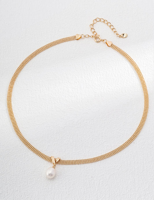 A gold chain necklace featuring a single elegant pearl, showcasing a blend of luxury and simplicity.