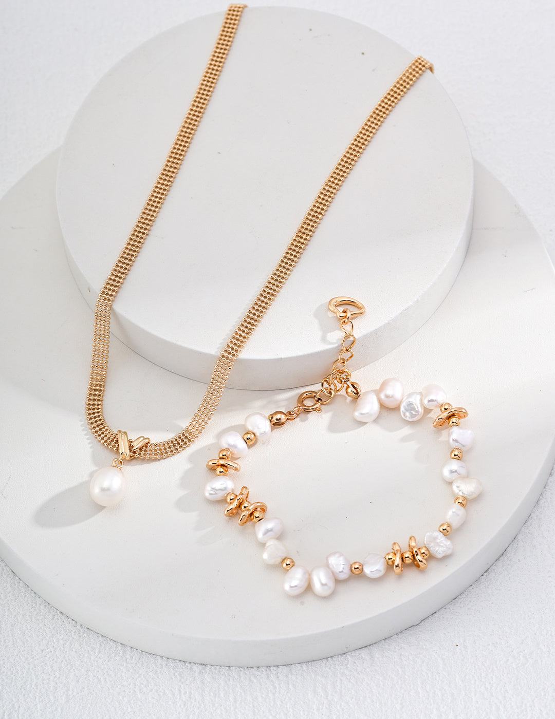 Stunning gold jewelry set featuring a necklace and bracelet, both embellished with exquisite pearls for a luxurious look.