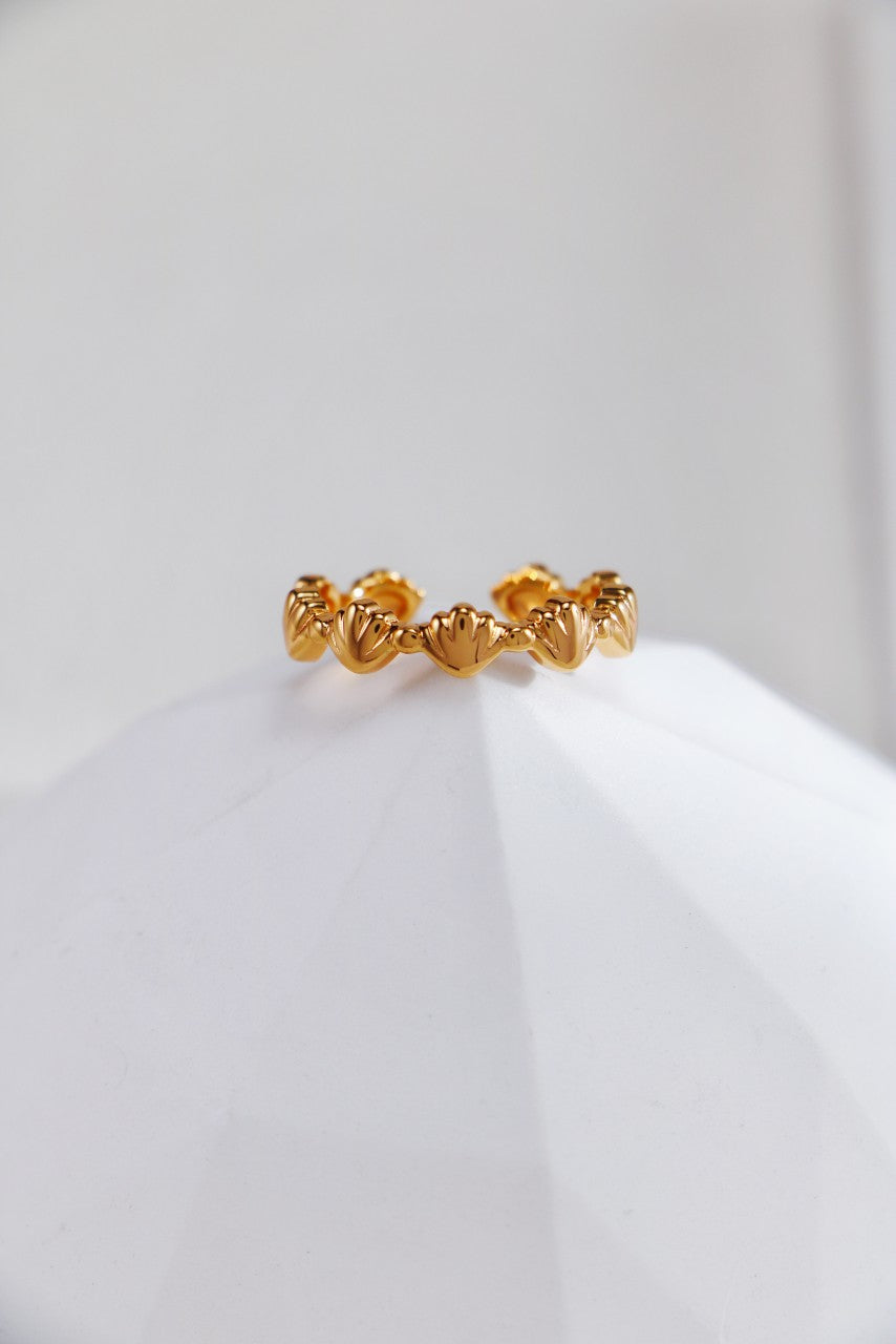 A delicate gold ring adorned with intricate small seashells designs, showcasing elegance and nature-inspired beauty.