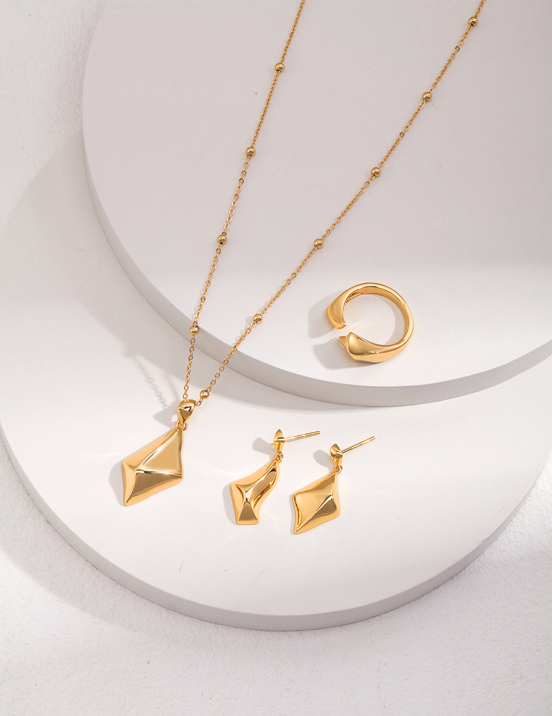 Stunning gold jewelry set featuring rhombus star pendant necklace, earrings, and ring.