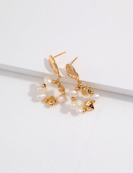 A pair of gold plated earrings with lustrous freshwater pearls, exuding elegance and sophistication.