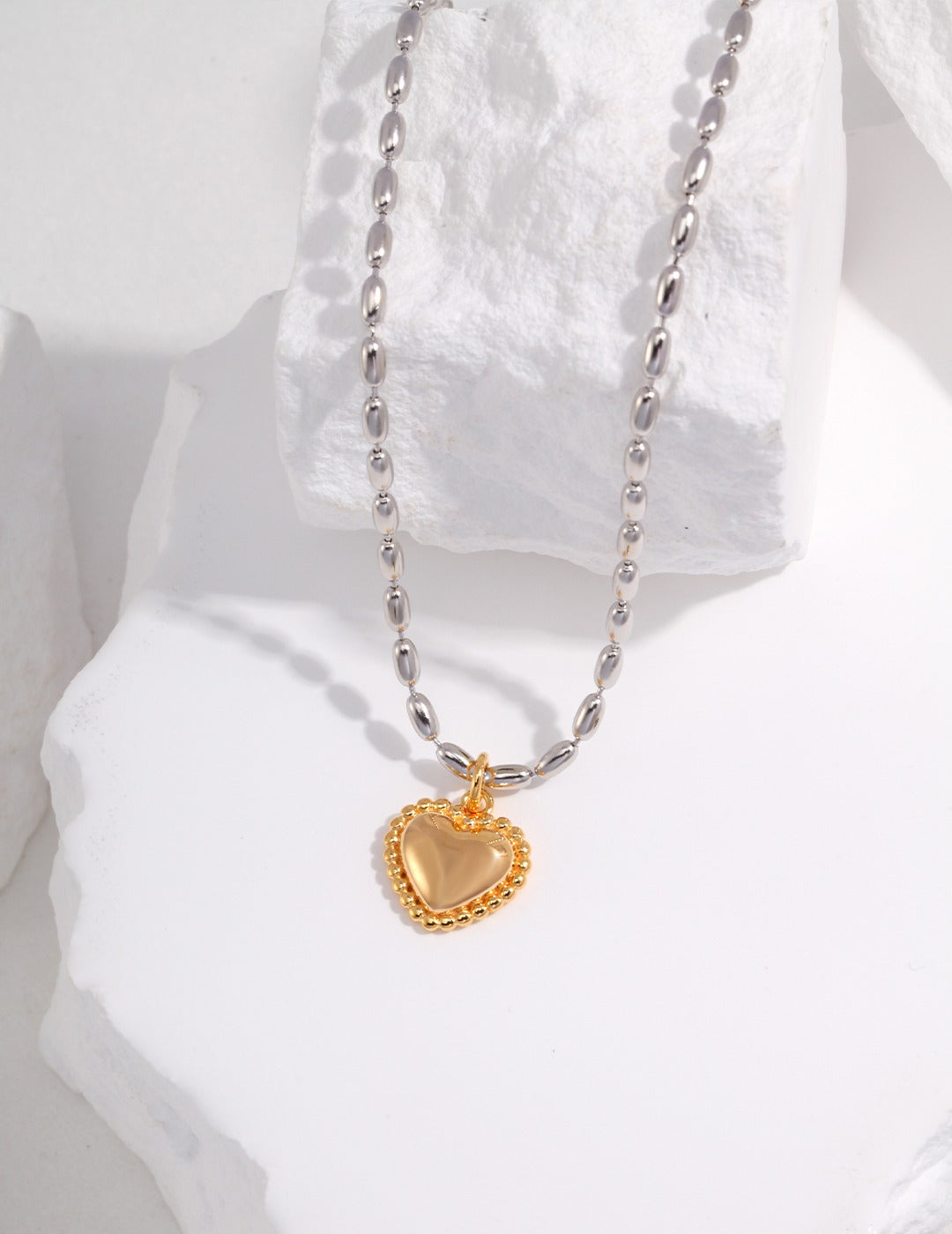 Silver beads chain necklace with gold heart pendant.