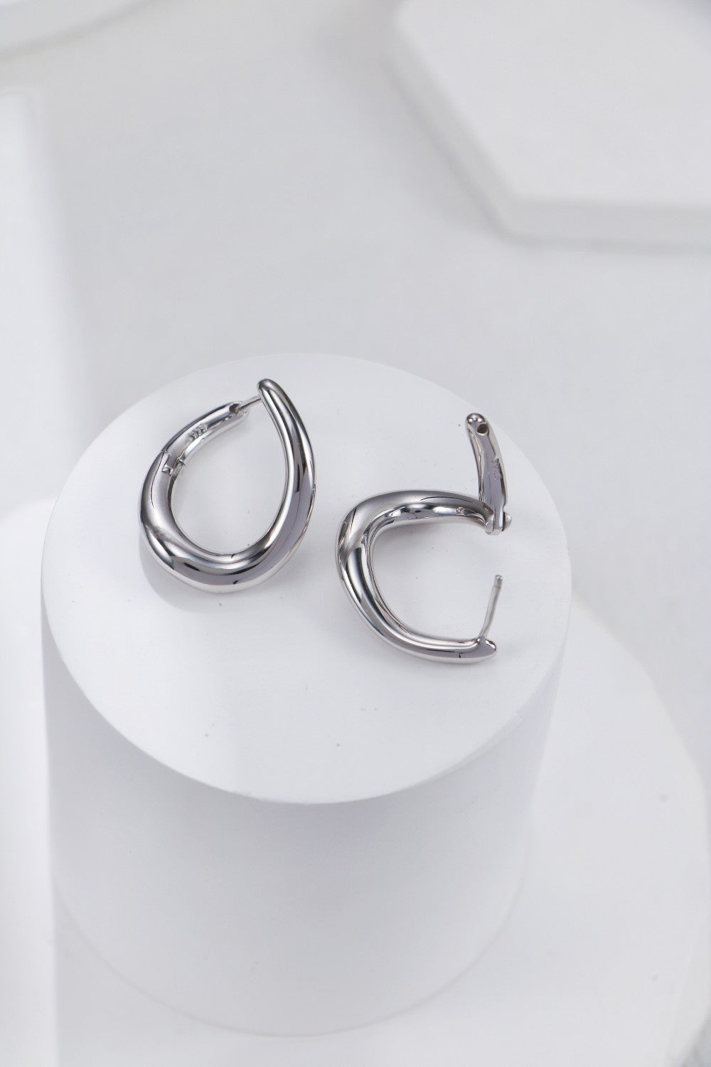 Silver hoop earrings on a white background, featuring both front and back perspectives for detailed viewing.