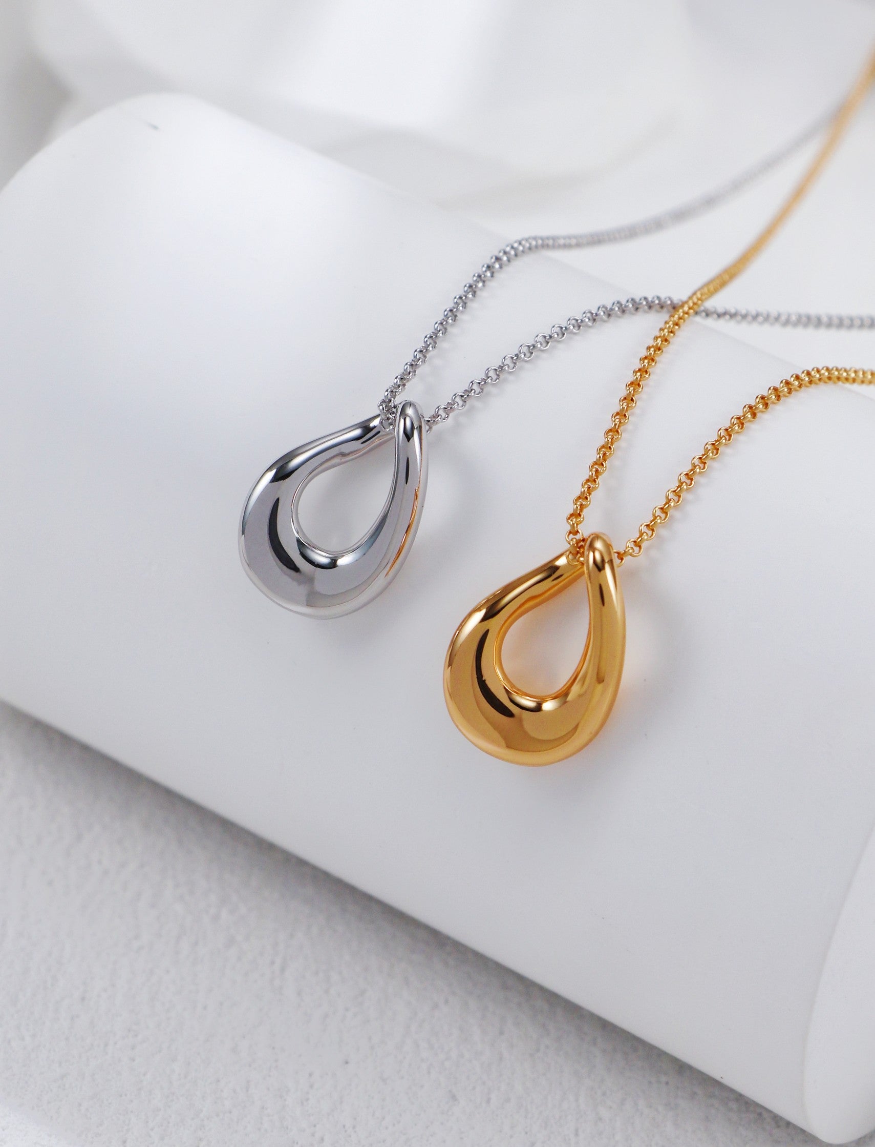 Two exquisite necklaces in gold and silver, each with a unique circular pendant, highlighting elegance and sophistication.