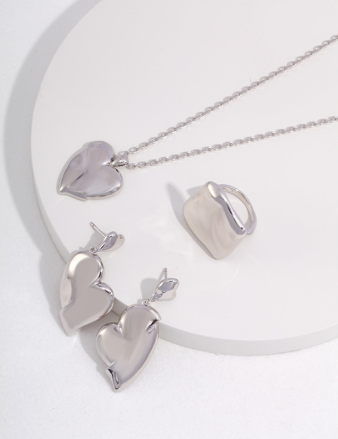  Heart-shaped silver jewelry set including necklace, ring, and earrings