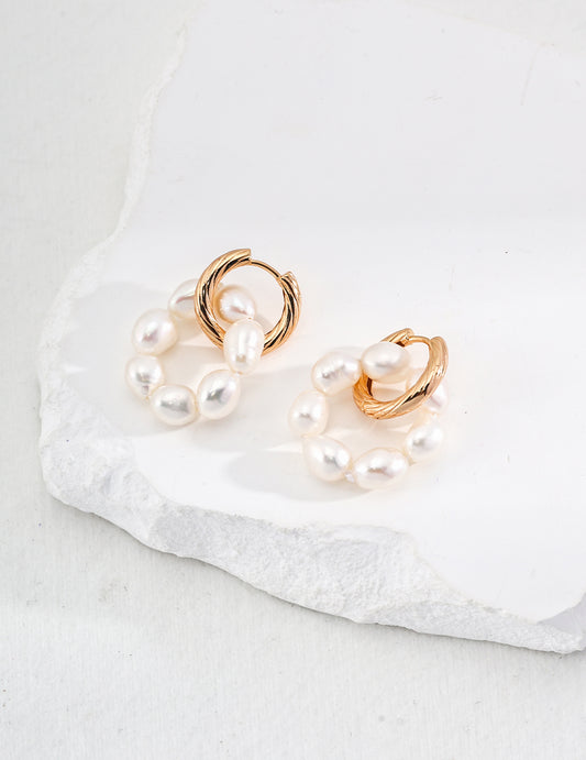 Freshwater pearl hoop earrings displayed on white.