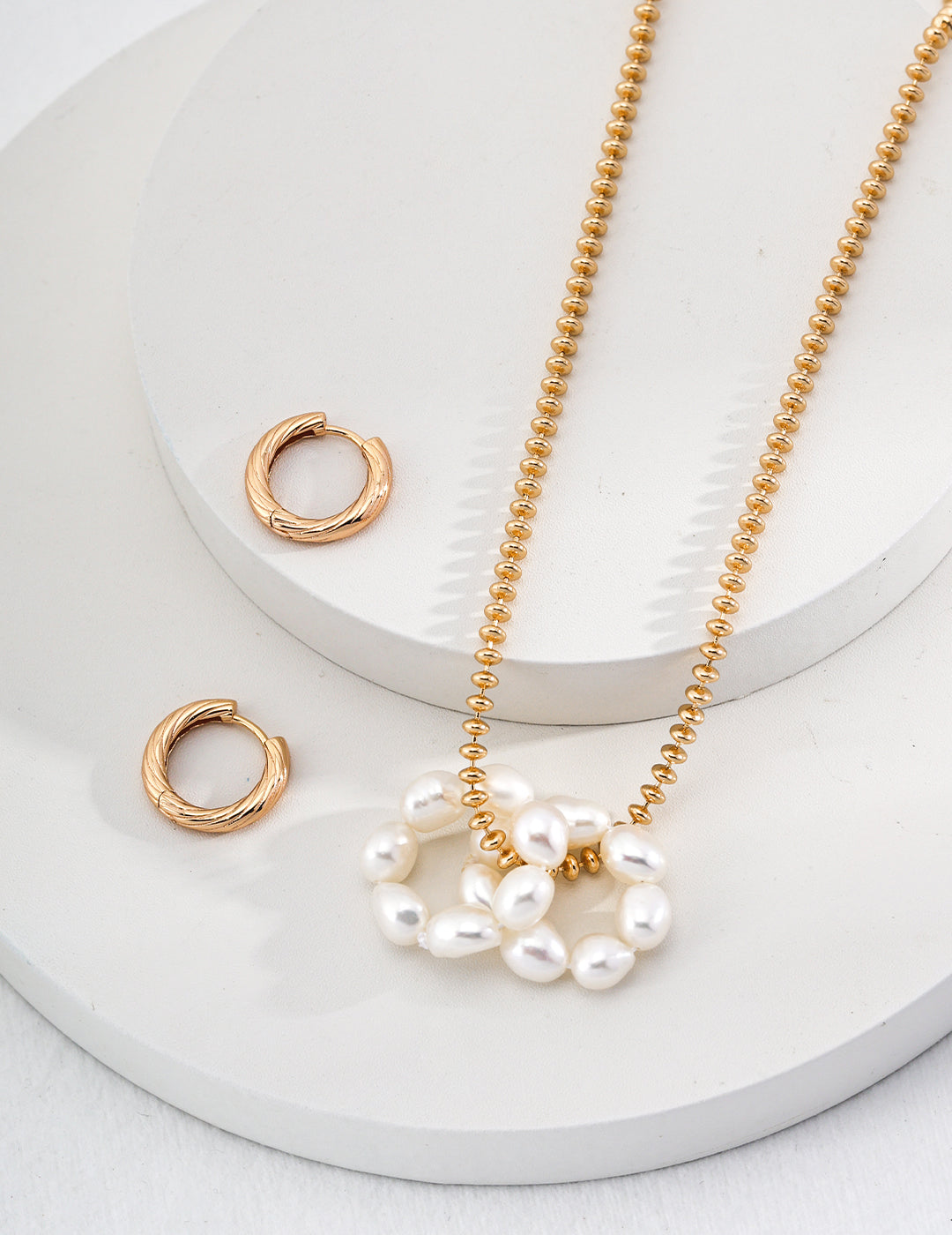 A stunning gold necklace with pearls and detachable freshwater pearl hoops that can also be worn as a necklace.