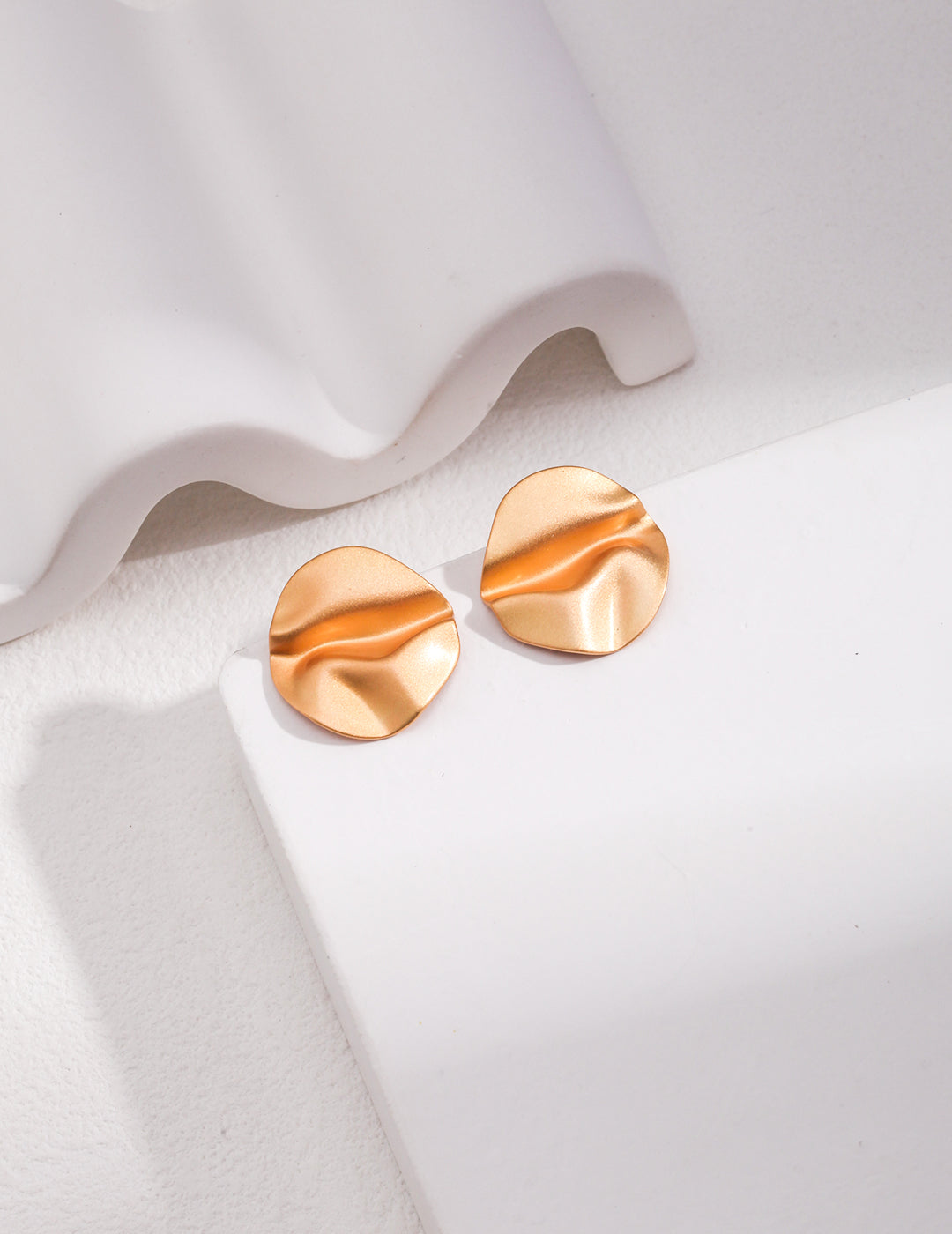 Gold plated earrings with a striking wave design, adding elegance and style to any outfit.