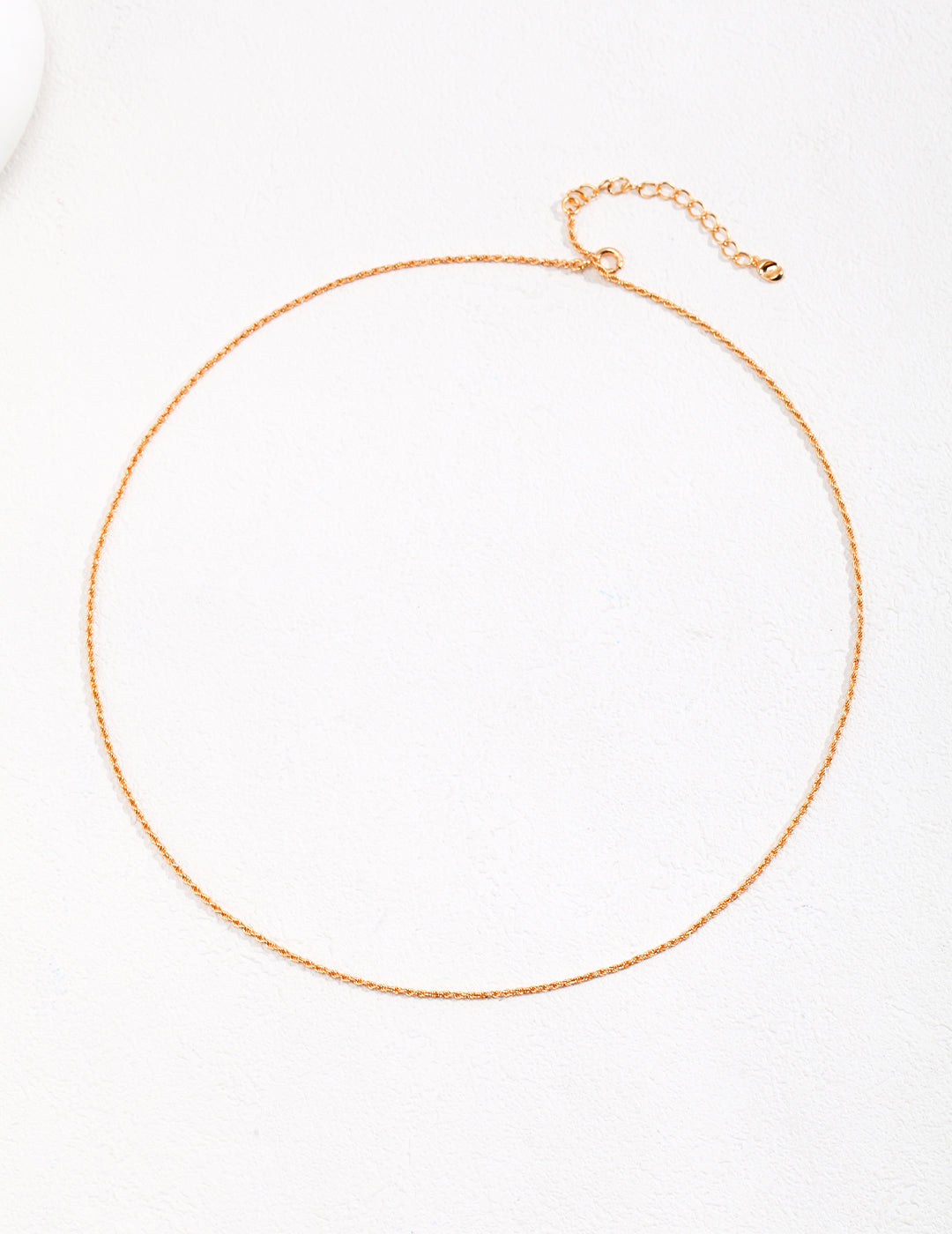 Gold necklace featuring a small chain design.