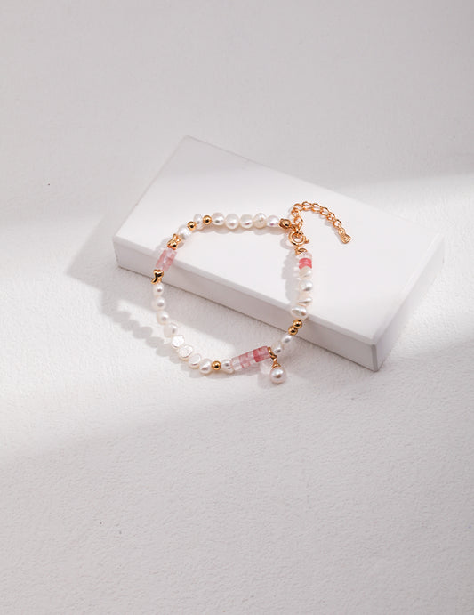 Elegant gold bracelet with freshwater pearls and lab-created ruby on white box.