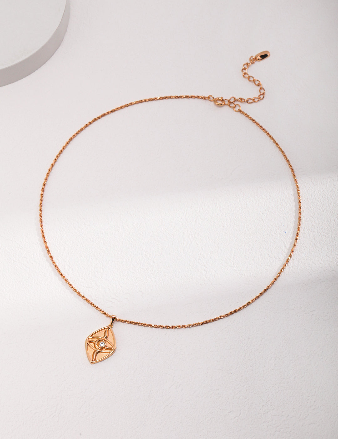 A gold plated necklace with a small cubic zirconia charm, shining in gold brilliance.