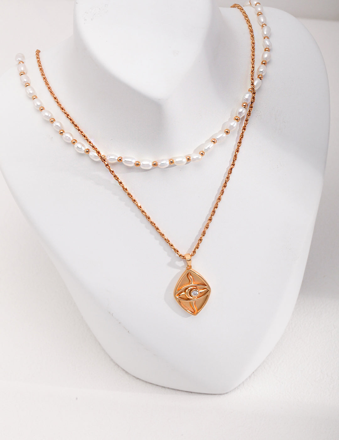 A gold pendant necklace adorned with pearl beads, featuring a layered design of gold plating and freshwater pearls.