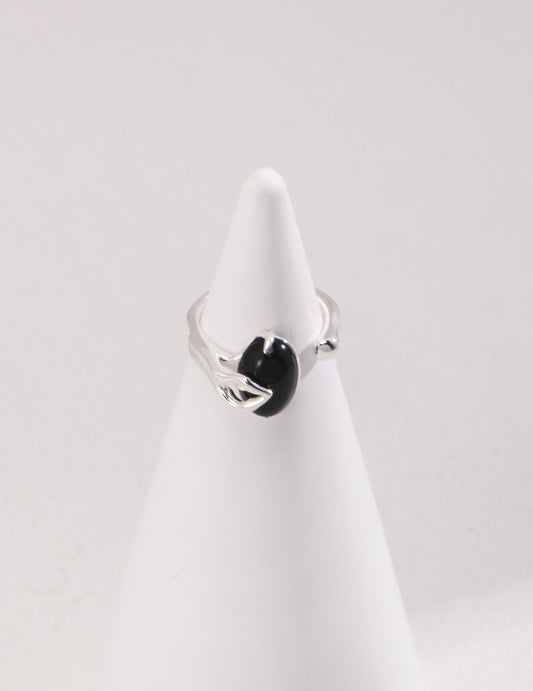 Silver ring with black agate stone on white cone.