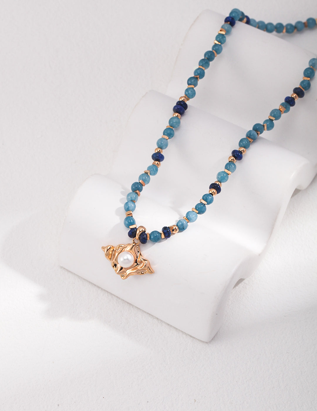 Elevate your look with a captivating blue necklace, boasting gold-plated accents and exquisite amazonite and lapis lazuli beads.