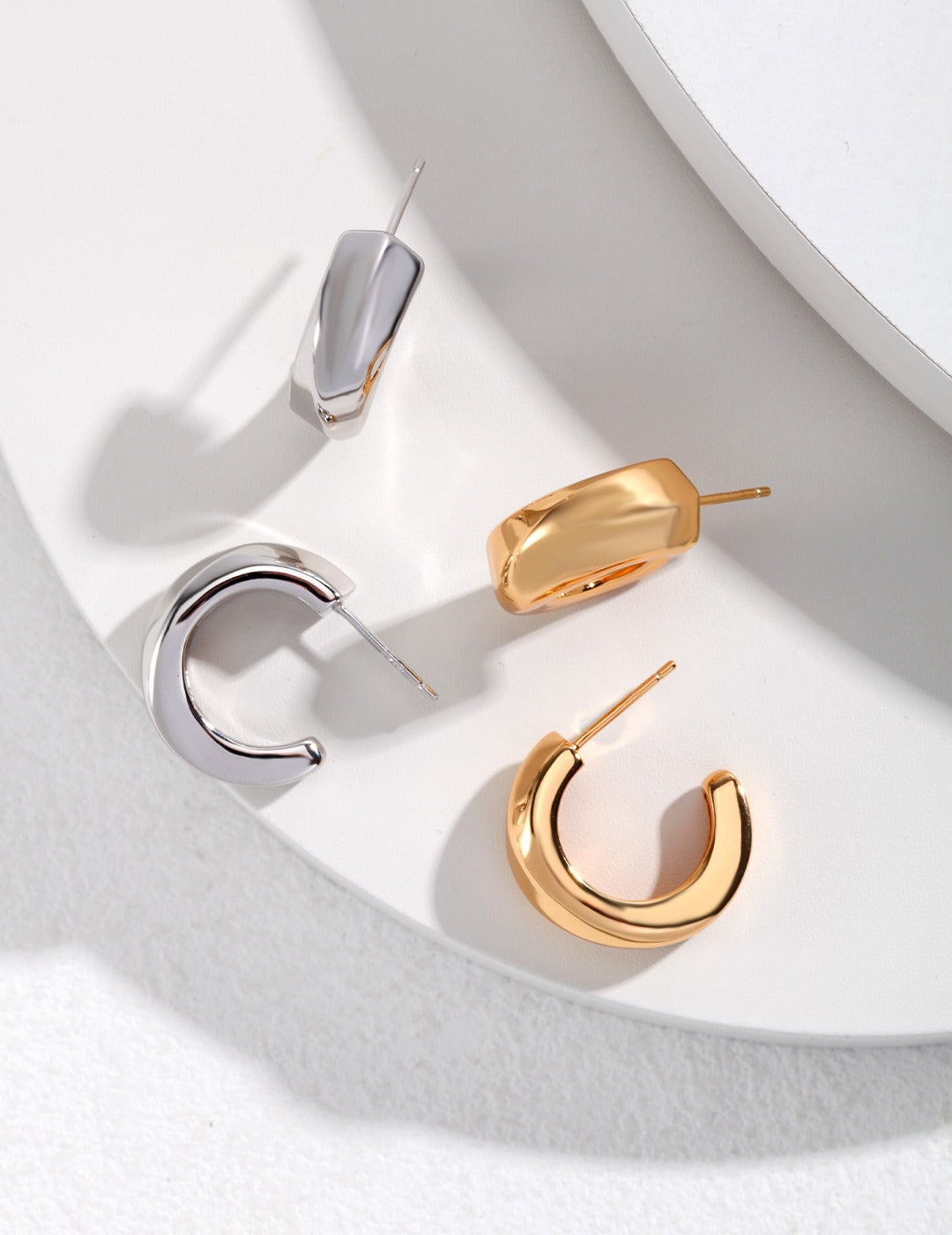 Two pairs of hoop earrings: one silver and one gold.