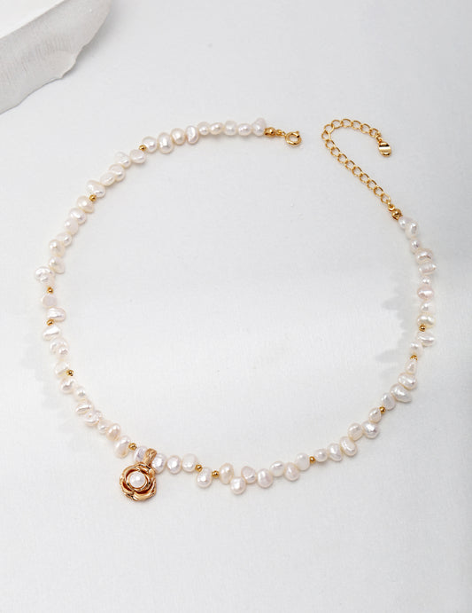 Gold plated necklace with camellia shaped pendant, freshwater pearls, and gold charm.