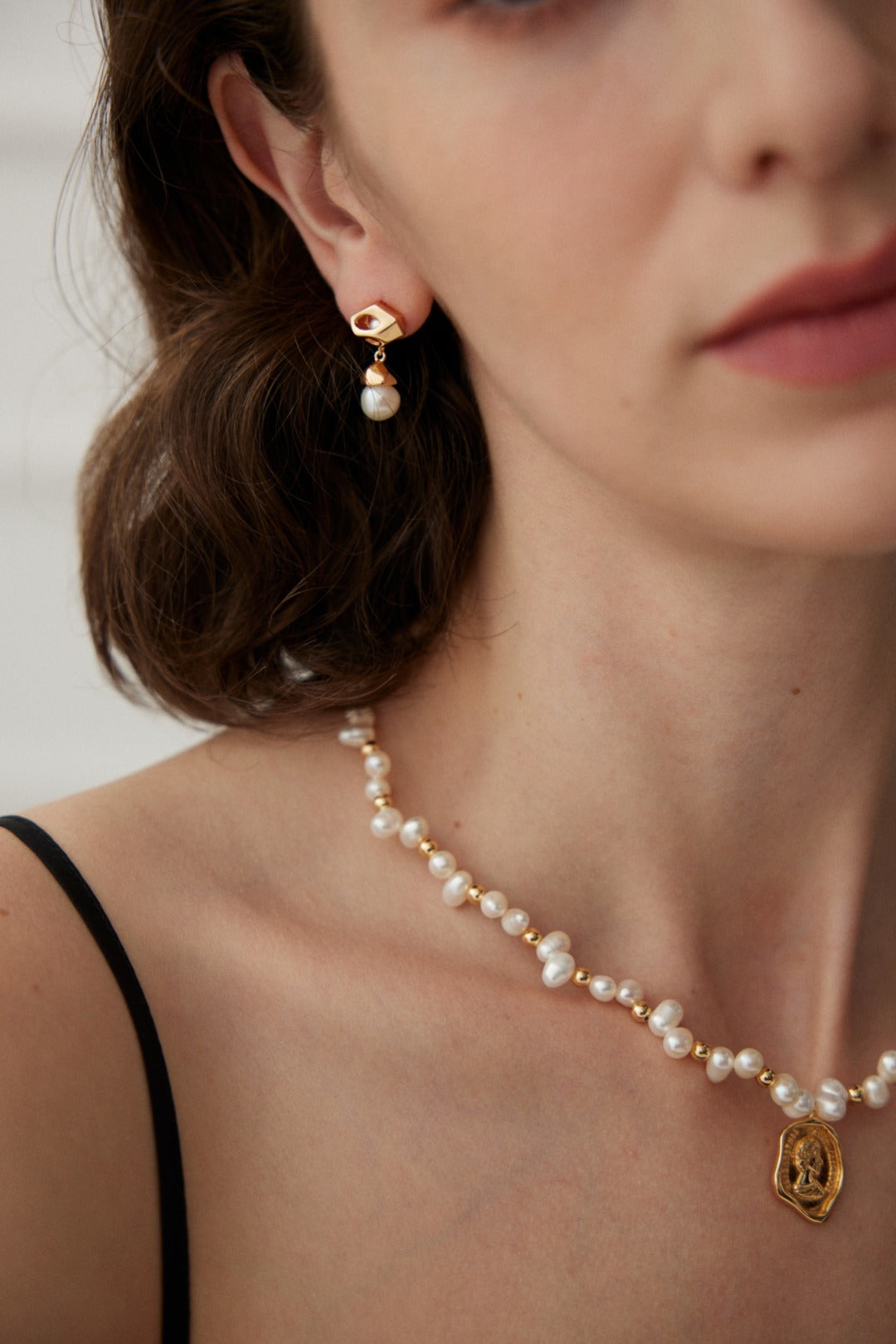 Profile view of the Catarina necklace on a model, highlighting the elegant drape of pearls and the high-end boutique aesthetic.