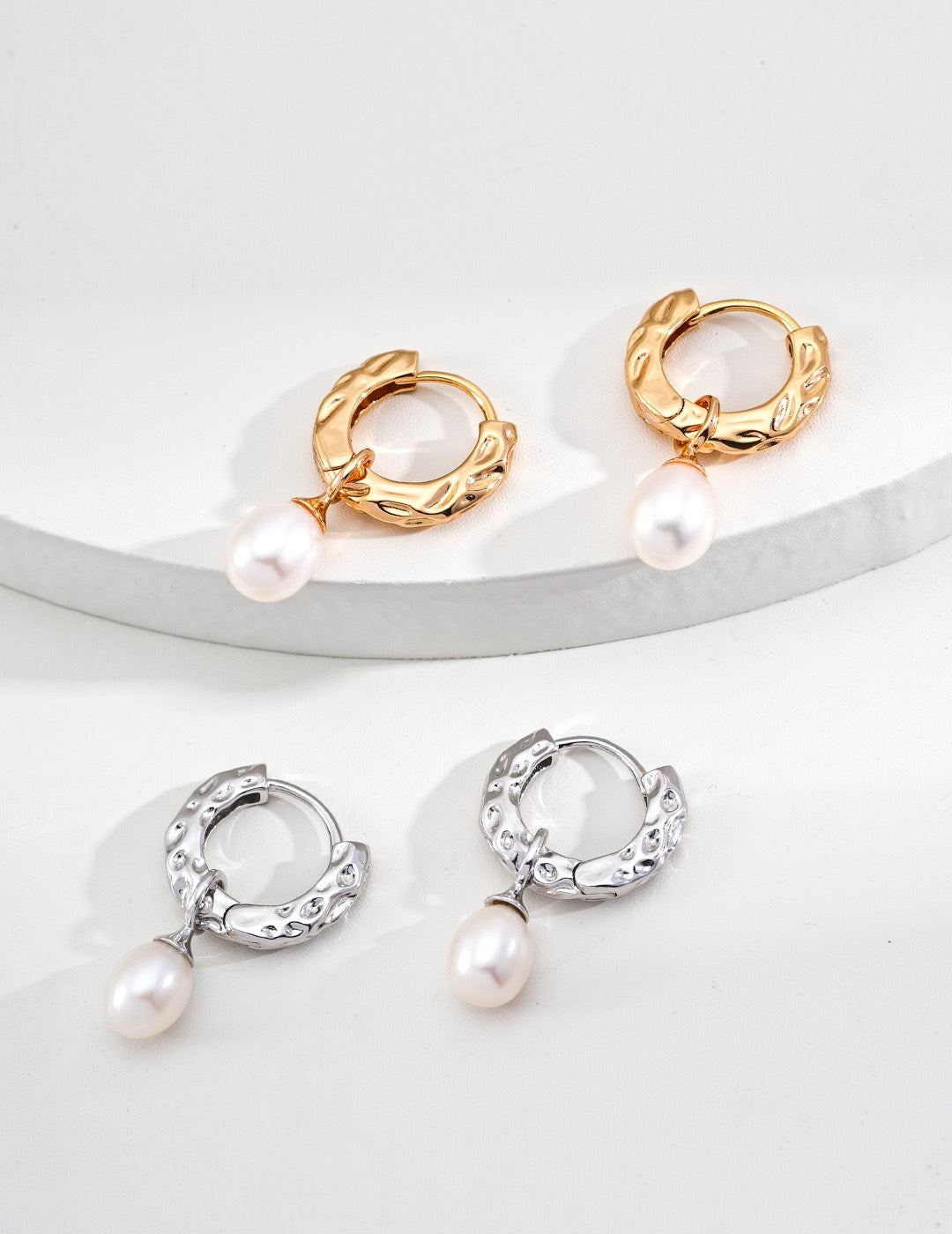 Two sets of Gold and silver Ceci Hoops with pearl drops on a white background, by Mezuille.