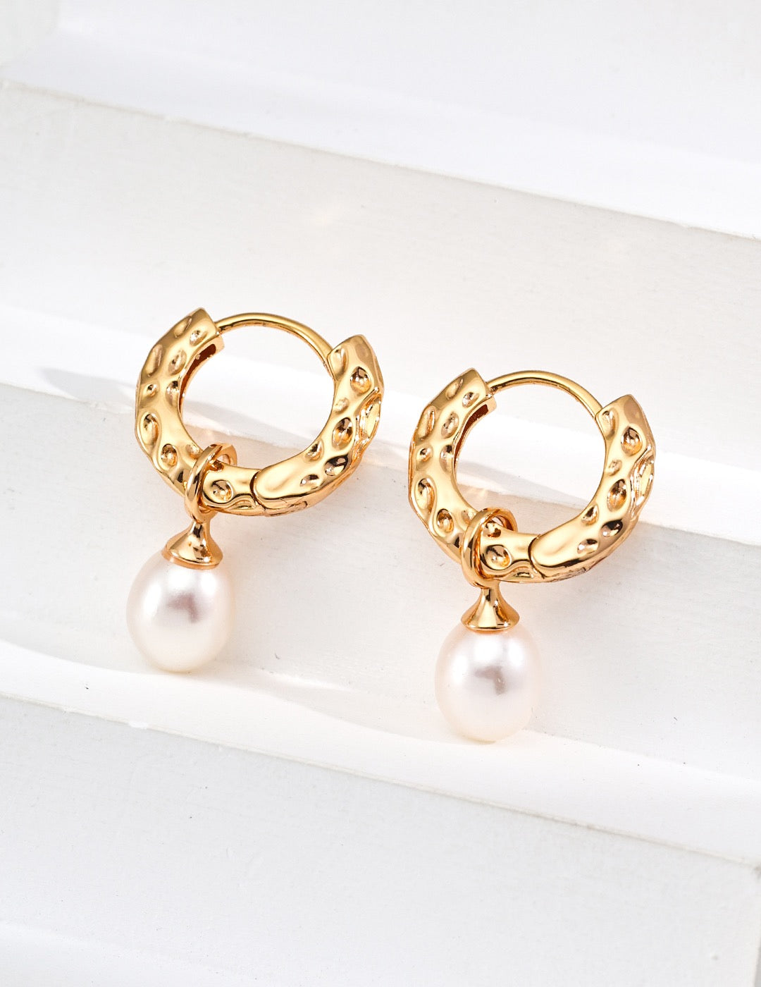 Close up of a pair of  Mezuille gold pearl hoops in S925 Silver.