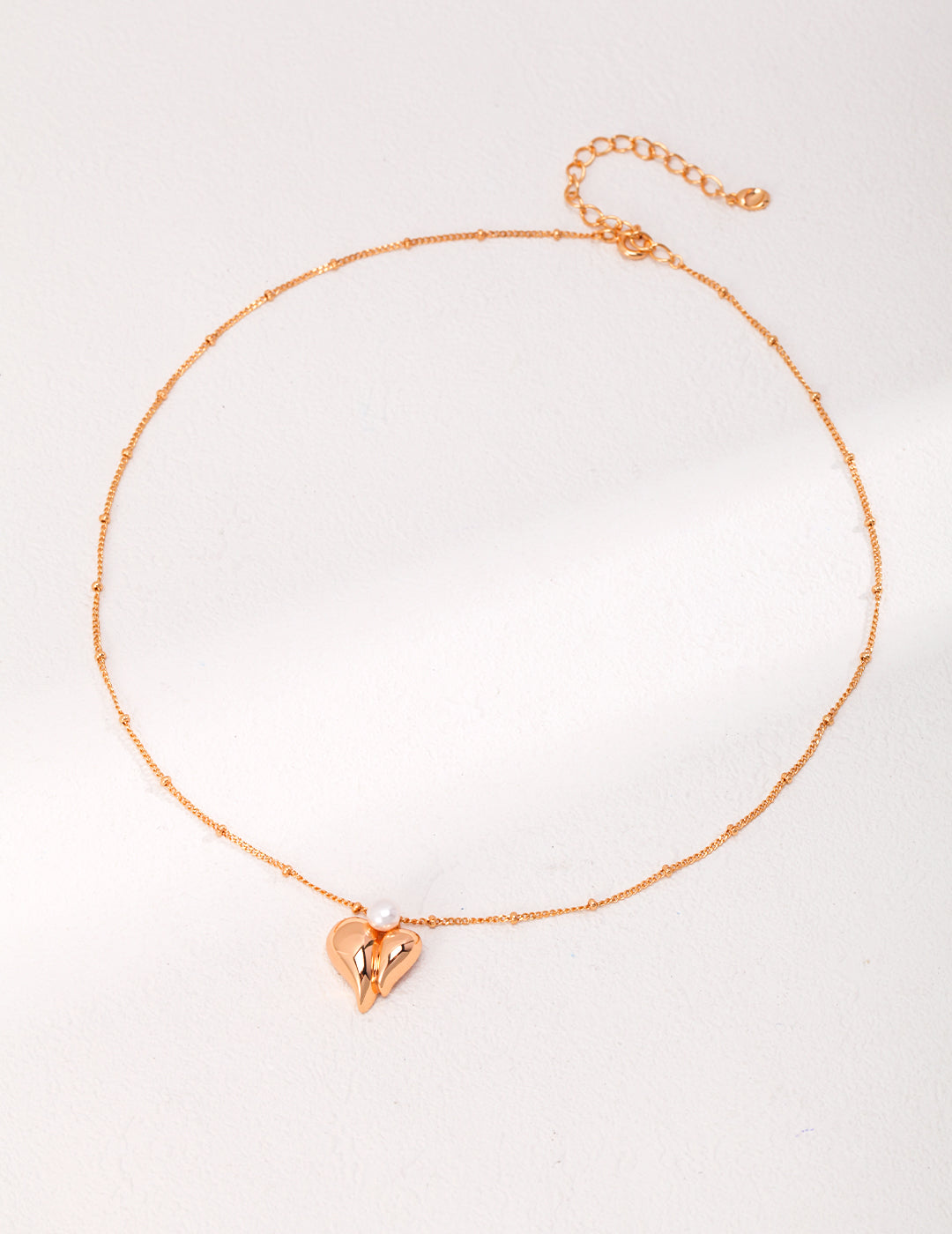 Gold necklace with heart charm, perfect for adding a touch of elegance to any outfit.