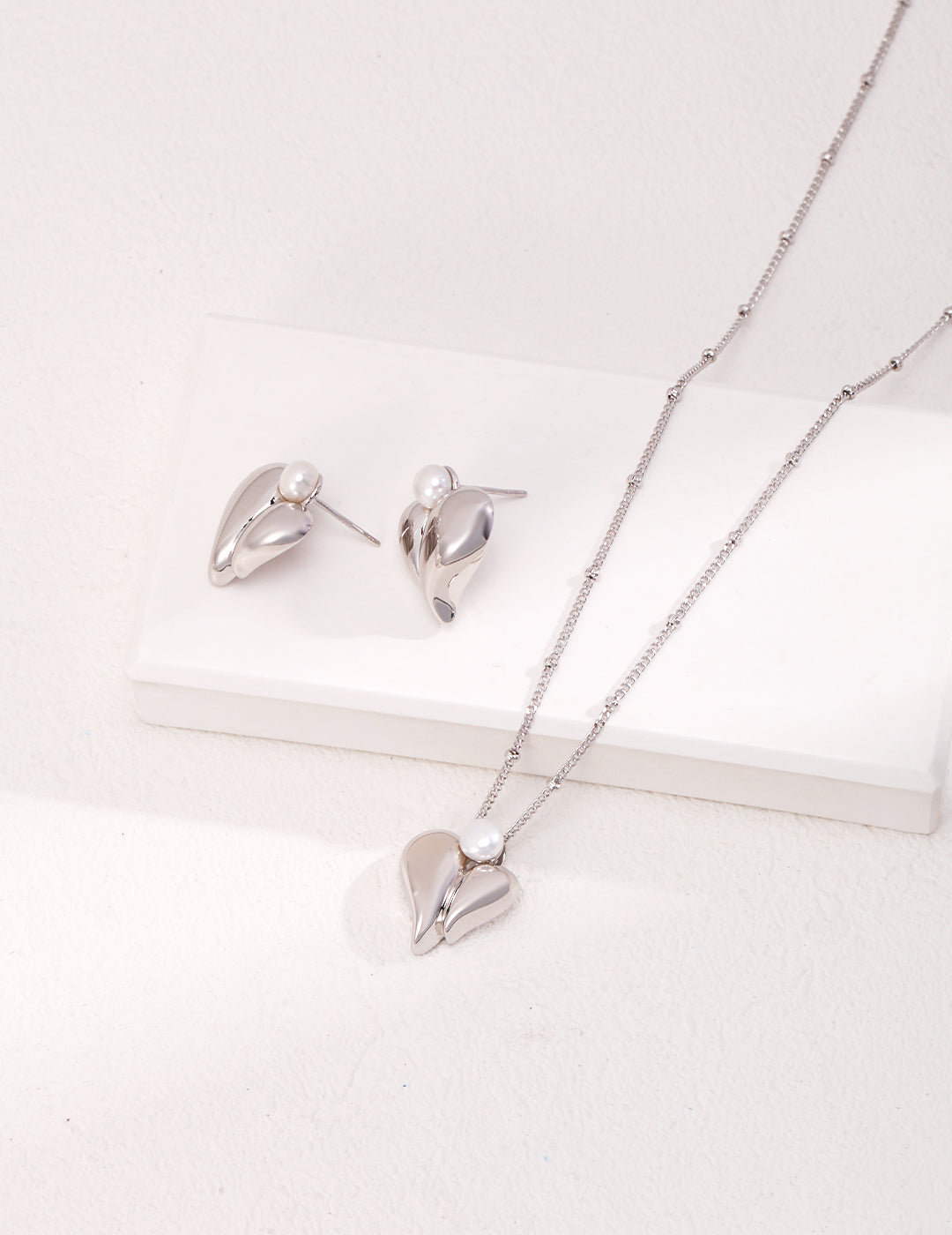 A beautiful set of silver heart-shaped necklace and earrings, perfect for adding a touch of elegance to any outfit.