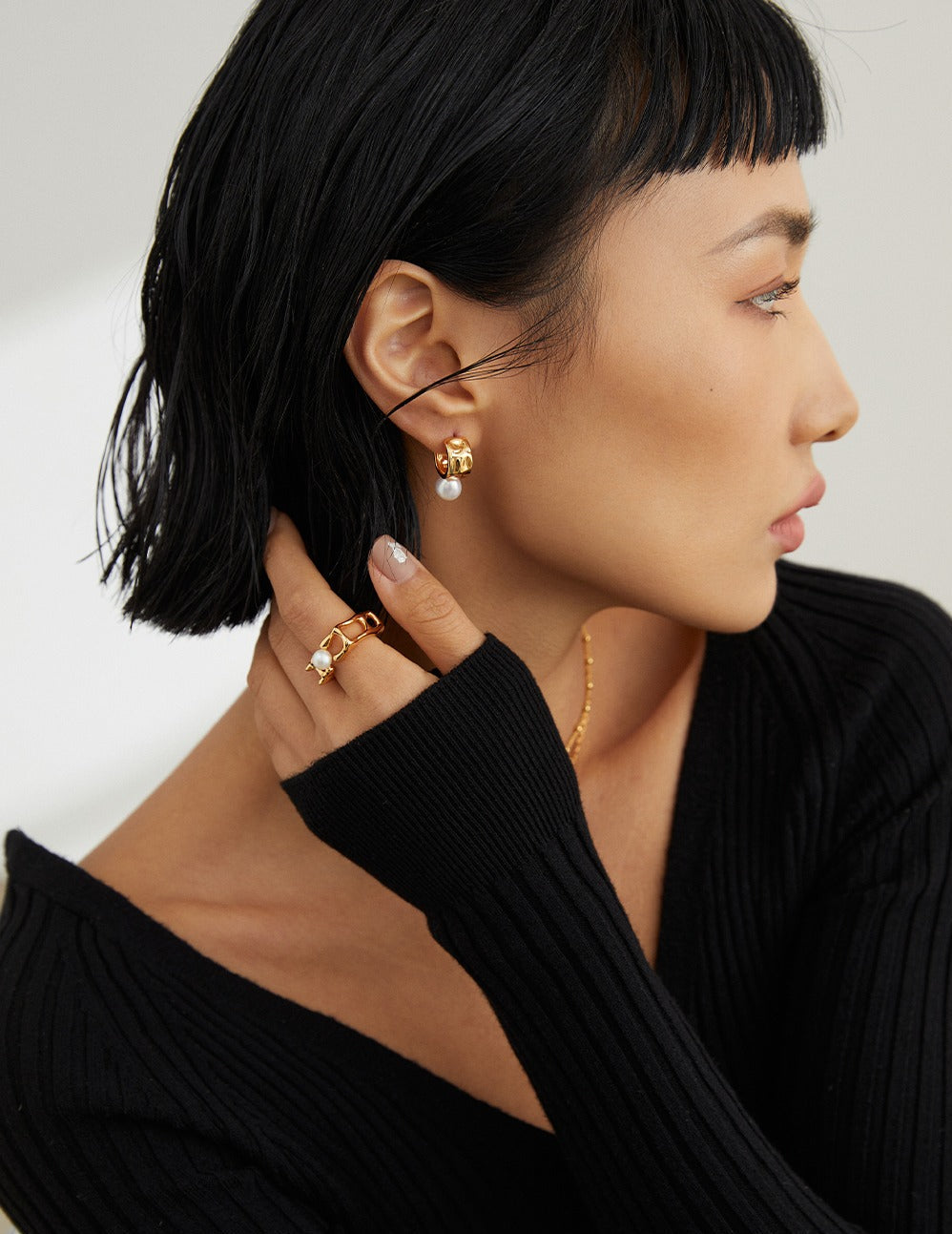 Woman wearing gold Vermeil pearl earrings and ring from Mezuille. 