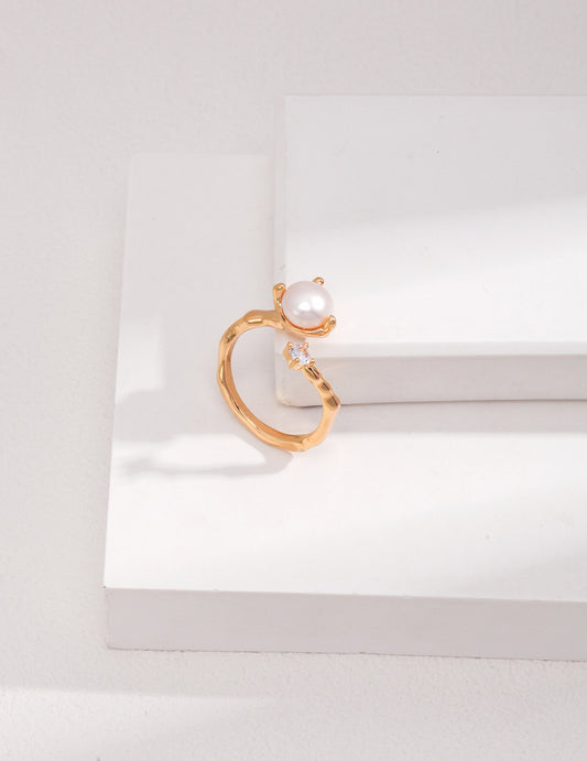 A stunning gold wrap ring featuring a lustrous pearl and sparkling cubic zirconia.