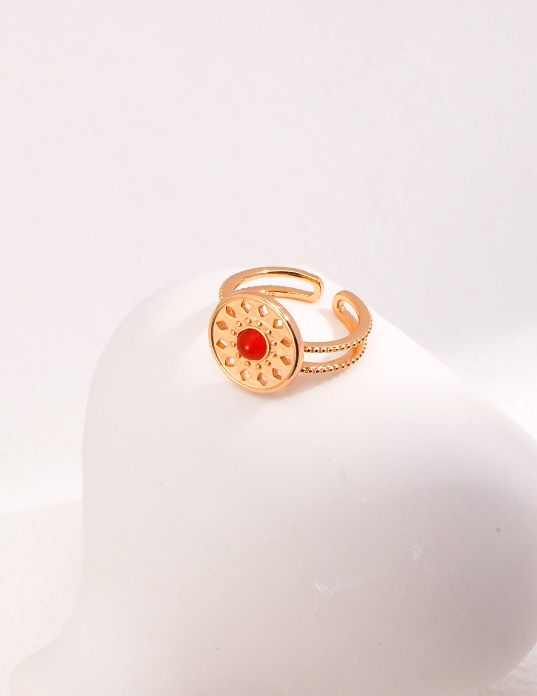 Stunning gold ring with red agate stone and one-of-a-kind totem motif.