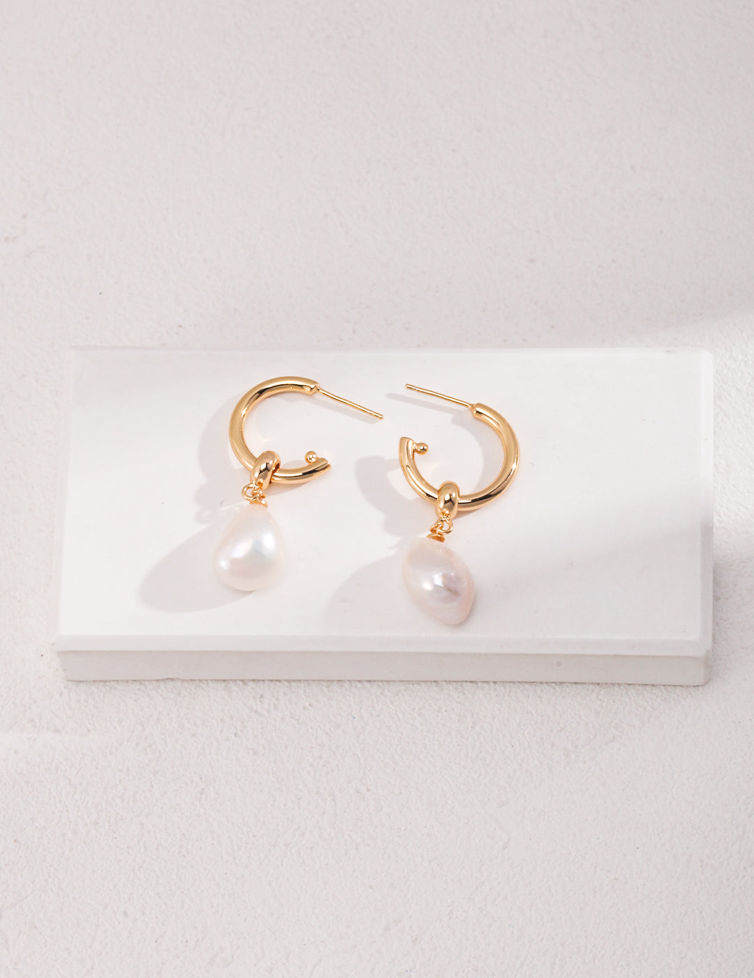 Elegant gold hoops adorned with baroque pearls.